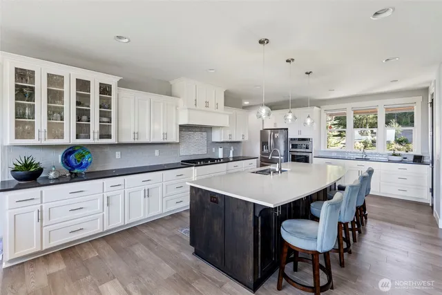 a large kitchen with kitchen island a dining table and chairs