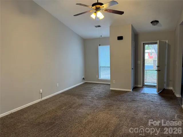 an empty room with closet and a chandelier fan
