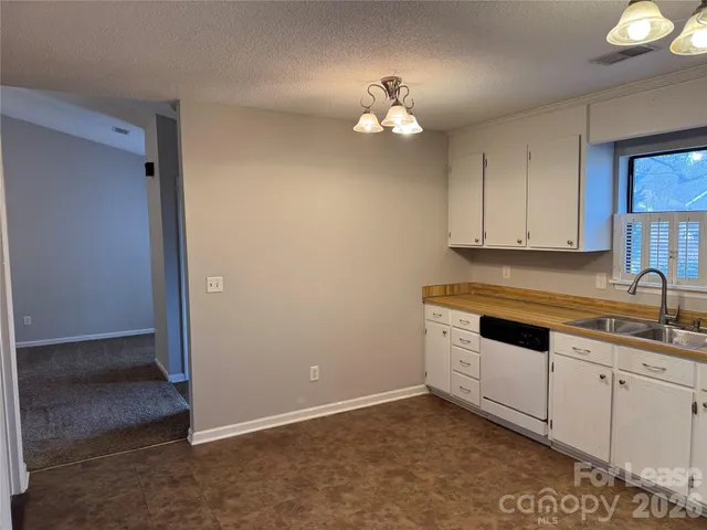 an empty room with a window and chandelier fan