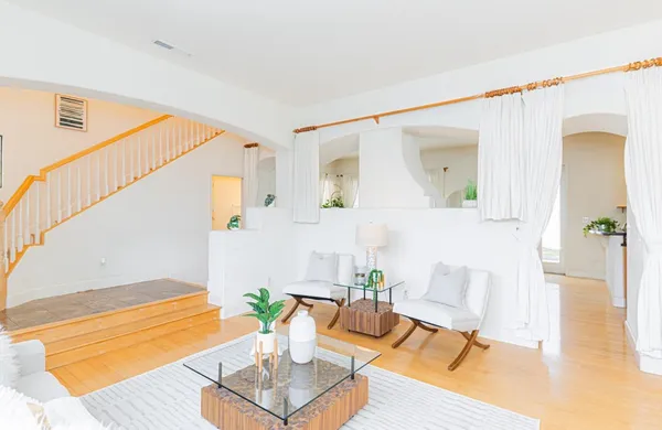 a living room with furniture and wooden floor