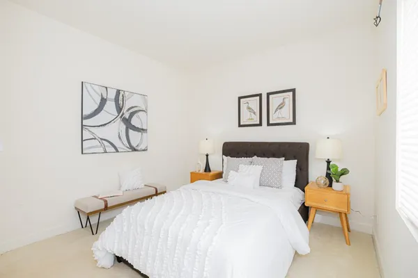 a bedroom with a bed and painting on the wall