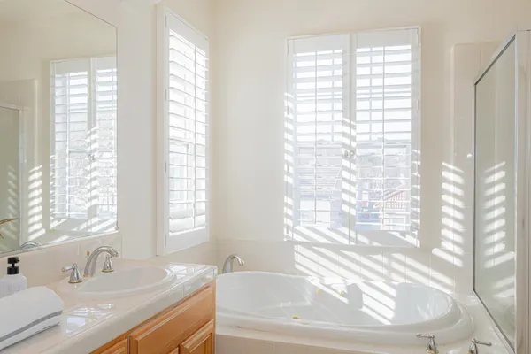 a bathroom with a granite countertop sink and a bathtub