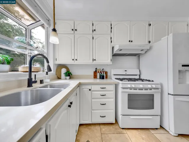 a kitchen with appliances a sink and cabinets