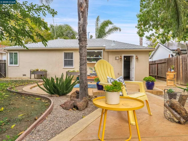a view of a house with backyard and sitting area