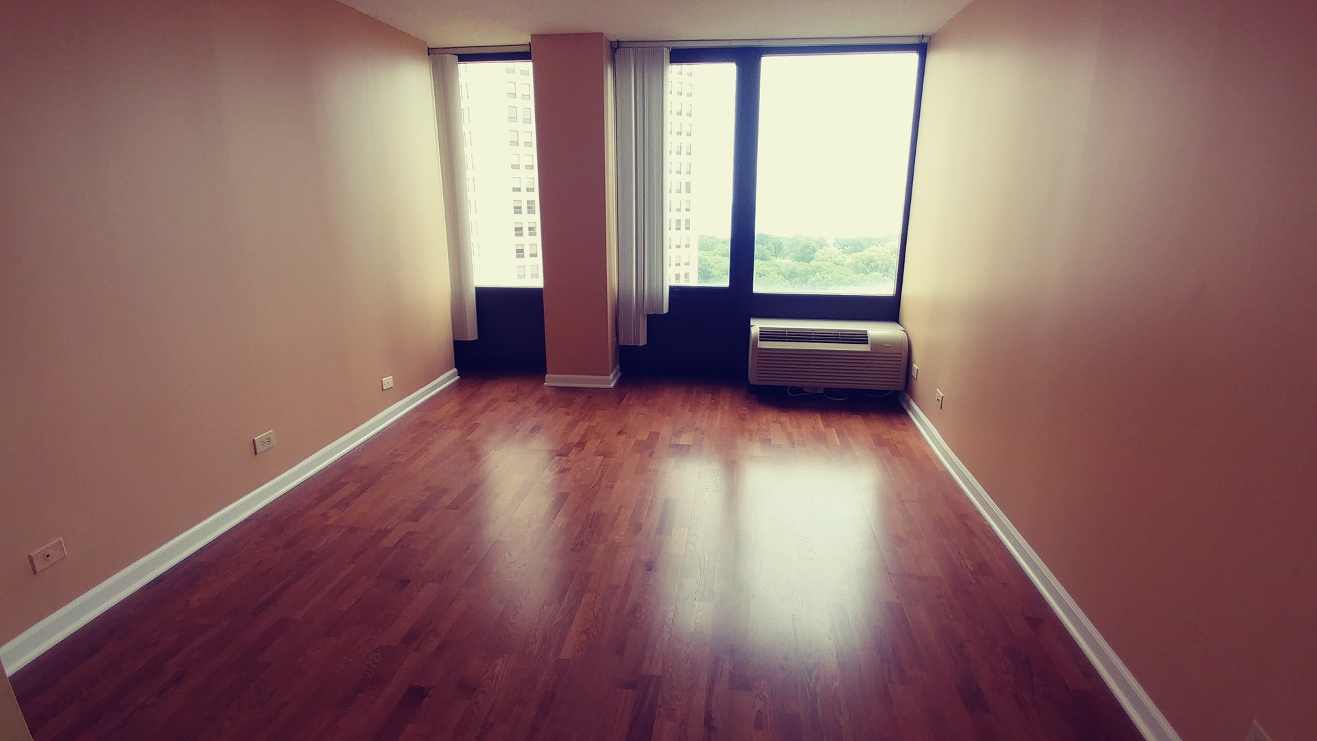 5320 North Sheridan Road, Unit 1207 Chicago, IL 60640 - Photo 12 of 20 an empty room with wooden floor and windows