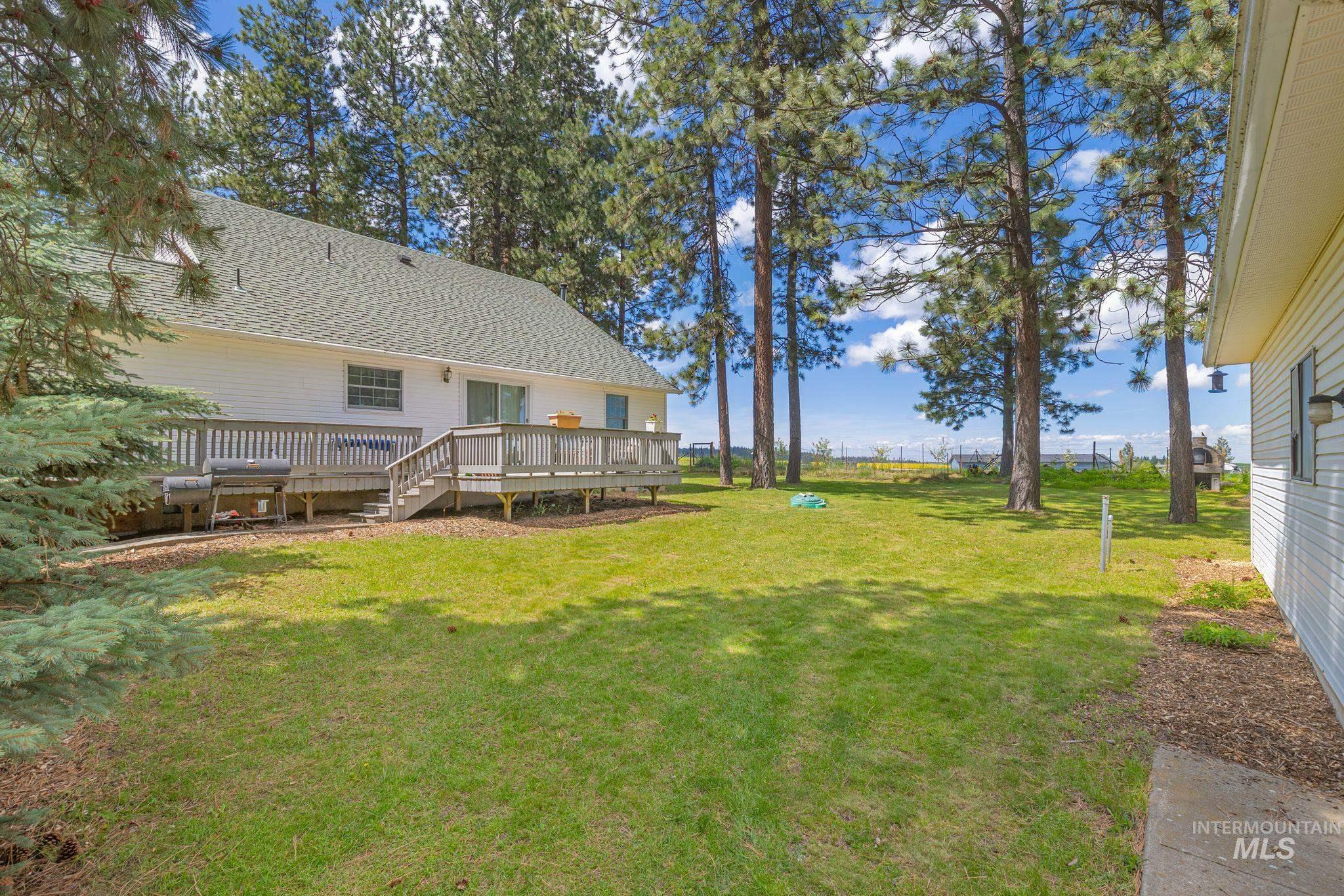1820 Winchester Road Winchester, ID 83555 - Photo 30 of 50 Expansive lawn area with mature trees, a multi-level wood deck, and white siding