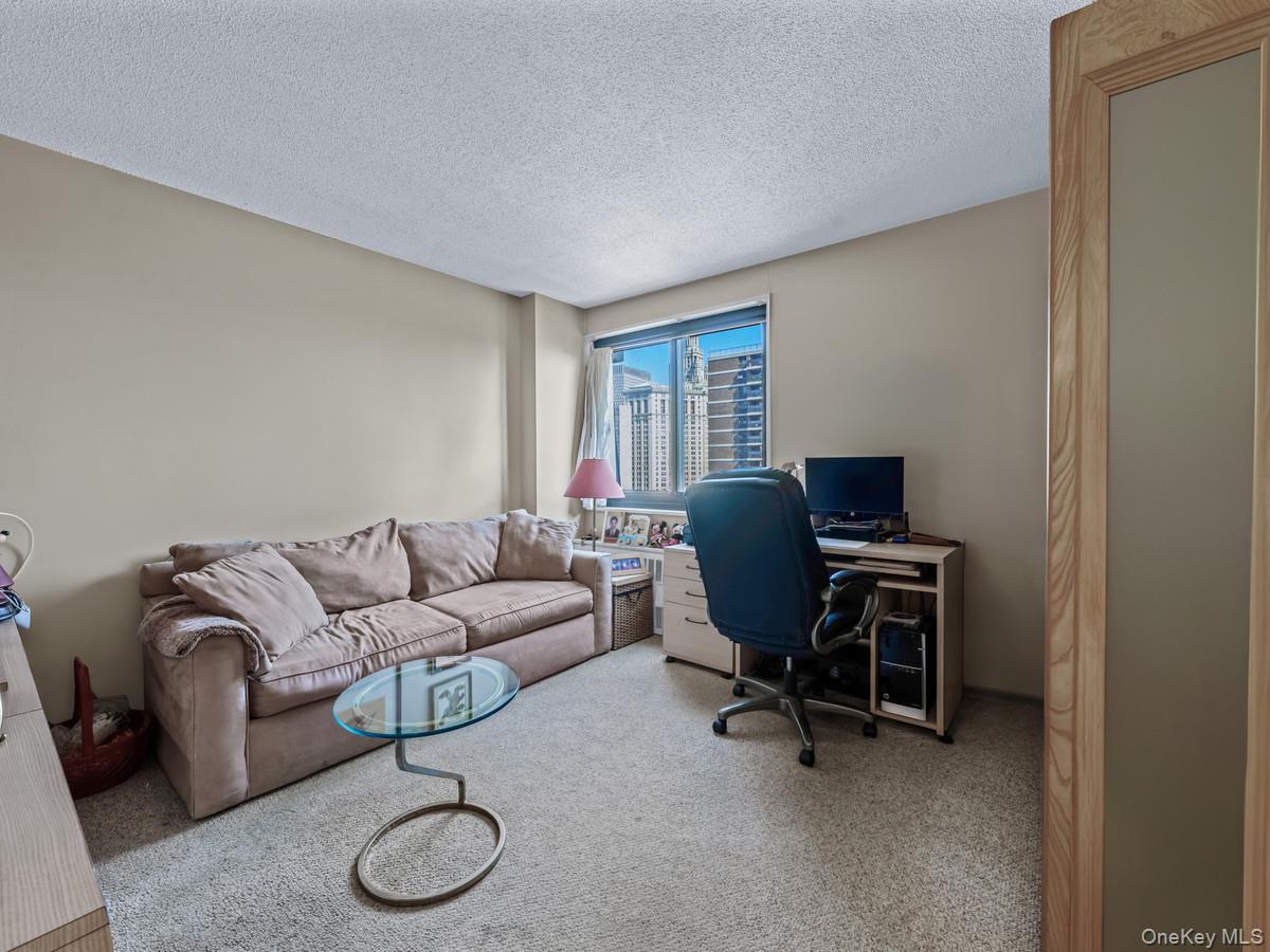 77 Fulton Street, Unit 19C Manhattan, NY 10038 - Photo 19 of 20 a living room with furniture a couch and a window