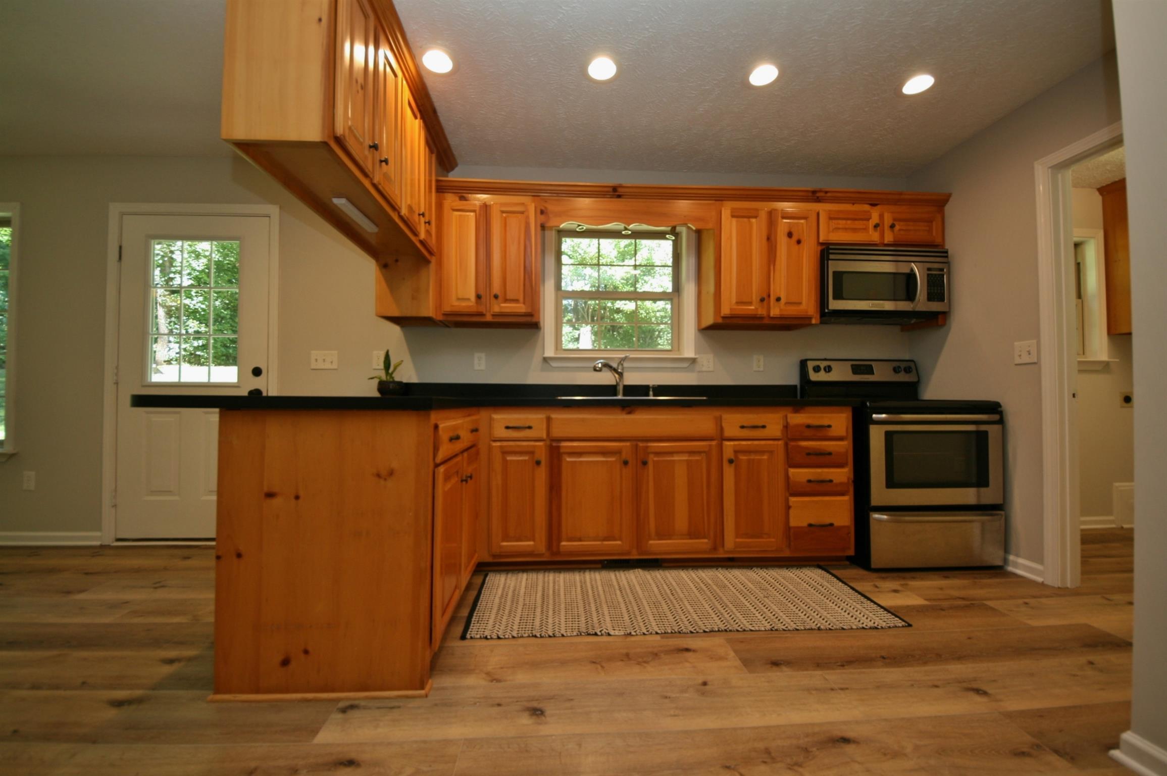 239 Union Ridge Road Wartrace, TN 37183 - Photo 10 of 30 Black counter-top with stainless steel stove and microwave