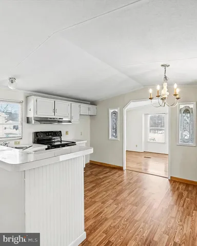 a open kitchen with cabinets a counter and chairs