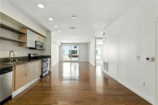 a kitchen with stainless steel appliances granite countertop a stove a sink and a refrigerator