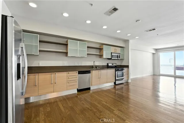 a kitchen with stainless steel appliances granite countertop a stove a sink and a refrigerator