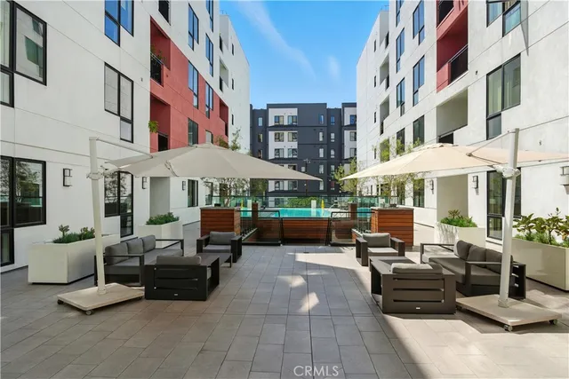 a view of a patio with dining table and chairs under an umbrella