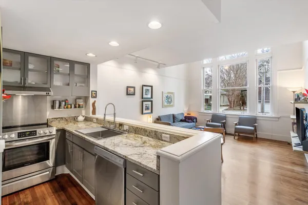 a kitchen with stainless steel appliances kitchen island granite countertop a refrigerator and a stove top oven