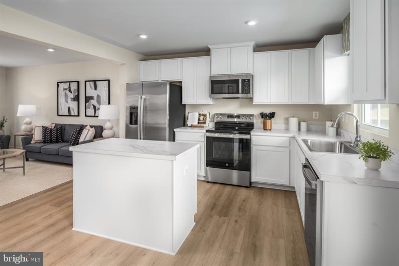 23 Debra Lane, Unit 53B Carlisle, PA 17013 - Photo 3 of 19 a kitchen with stainless steel appliances granite countertop a stove top oven a sink a refrigerator white cabinets and wooden floor