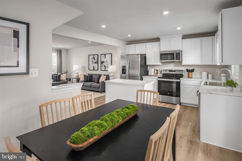 23 Debra Lane, Unit 53B Carlisle, PA 17013 - Photo 4 of 19 a view of a kitchen with kitchen island stainless steel appliances wooden floor dining table and chairs