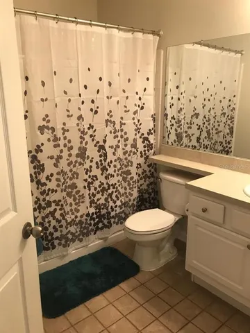 a bathroom with a toilet and a shower curtain