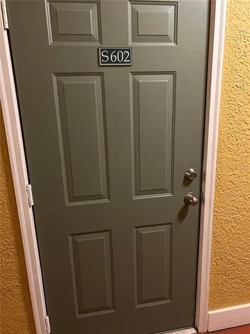 a view of a patio with table and chairs potted plants and large tree