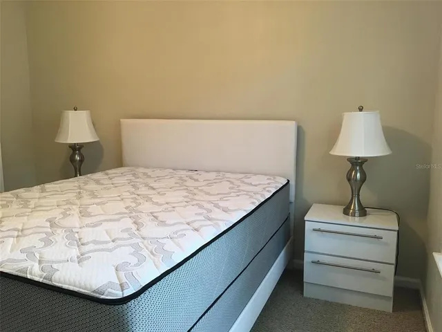 a bed sitting in a bedroom next to a lamp