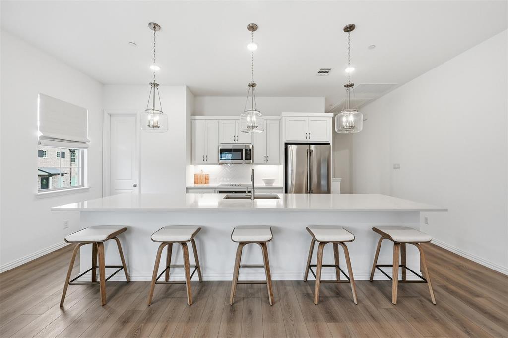 634 Blue Rdg Drive Mansfield, TX 76063 - Photo 3 of 25 a kitchen with stainless steel appliances granite countertop a dining table chairs refrigerator and microwave