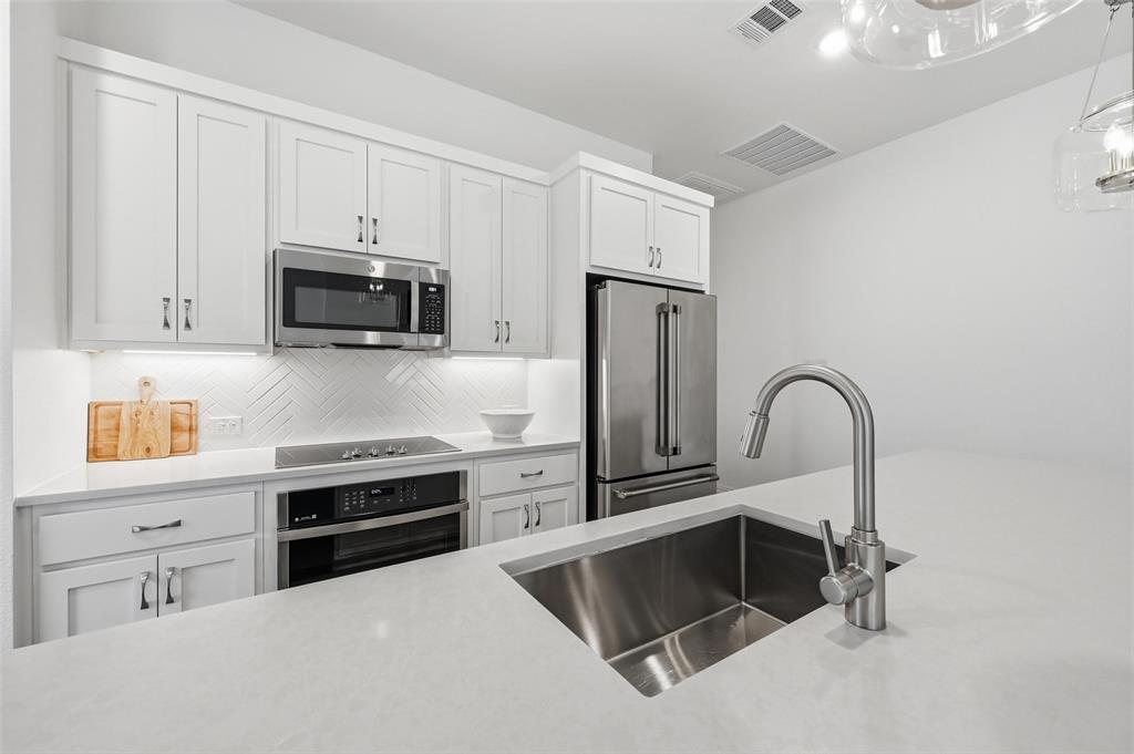634 Blue Rdg Drive Mansfield, TX 76063 - Photo 6 of 25 a kitchen with stainless steel appliances a stove microwave and sink