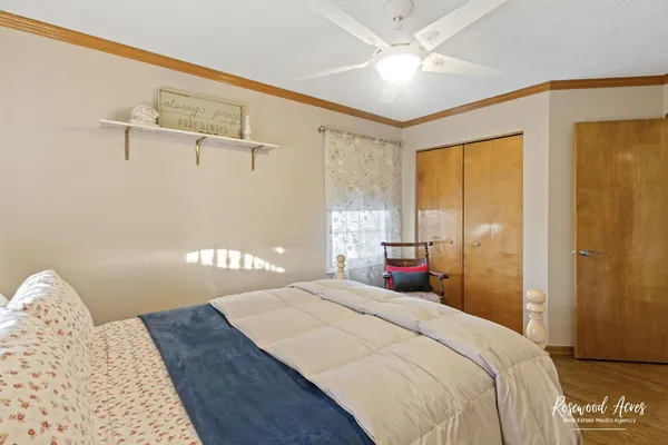 a bedroom with a bed and a chandelier fan