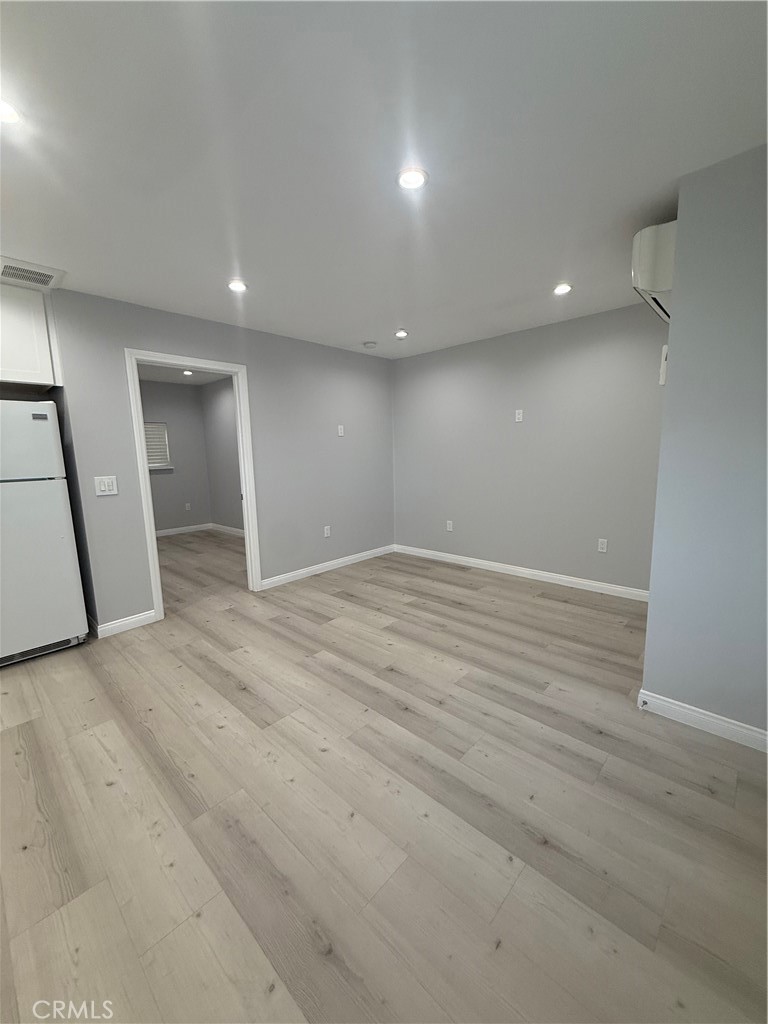 6504 Hesperia Avenue Reseda, CA 91335 - Photo 8 of 11 an empty room with wooden floor and natural light