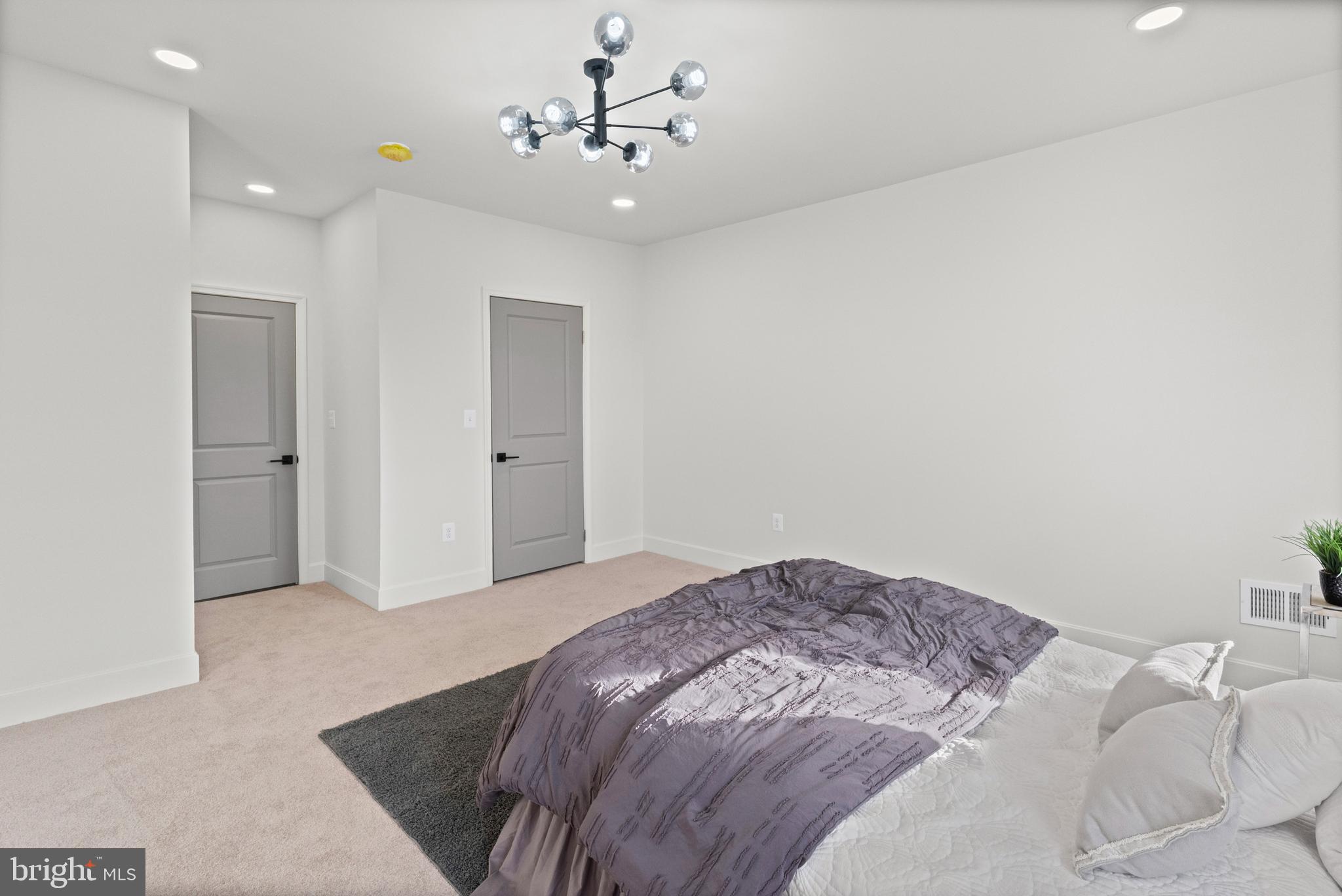 317 South Fulton Avenue Baltimore, MD 21223 - Photo 14 of 44 a bedroom with a bed and a chandelier