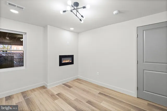 a view of an empty room with wooden floor