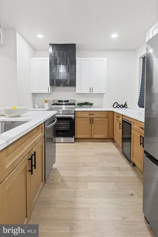 a large kitchen with stainless steel appliances granite countertop a stove a sink dishwasher and a refrigerator