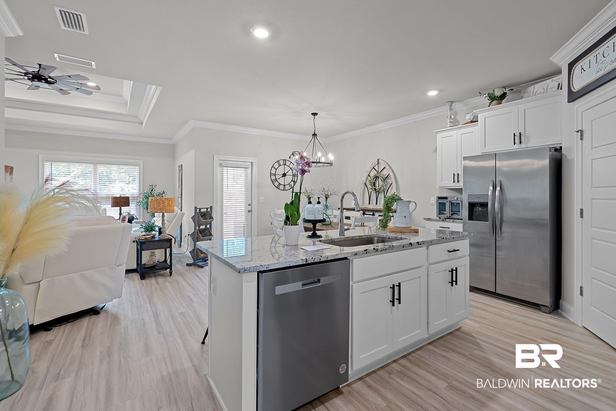 13966 Antler Hl Road Daphne, AL 36527 - Photo 6 of 44 Kitchen island featuring a double basin sink, stainless steel dishwasher, and a light-toned countertop