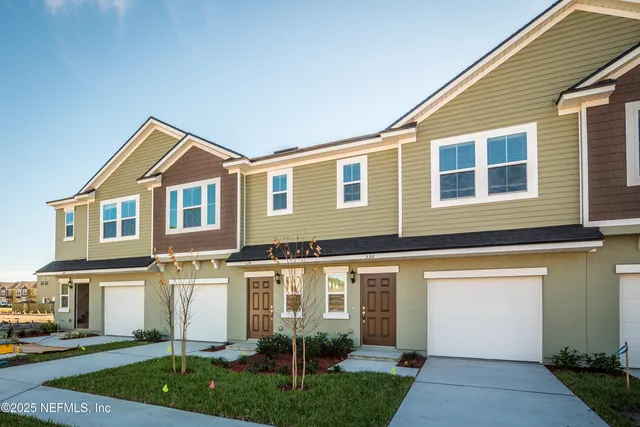 a front view of a house with a garden and plants
