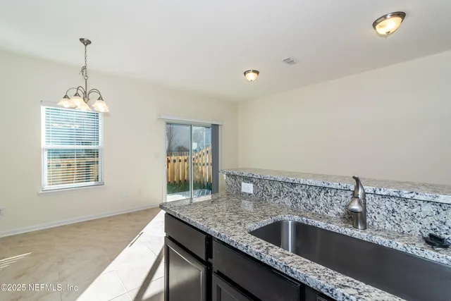 a kitchen with a sink and chandelier