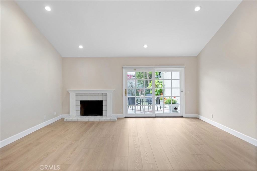 10 Coldstream, Unit 50 Irvine, CA 92604 - Photo 11 of 50 an empty room with wooden floor fireplace and windows