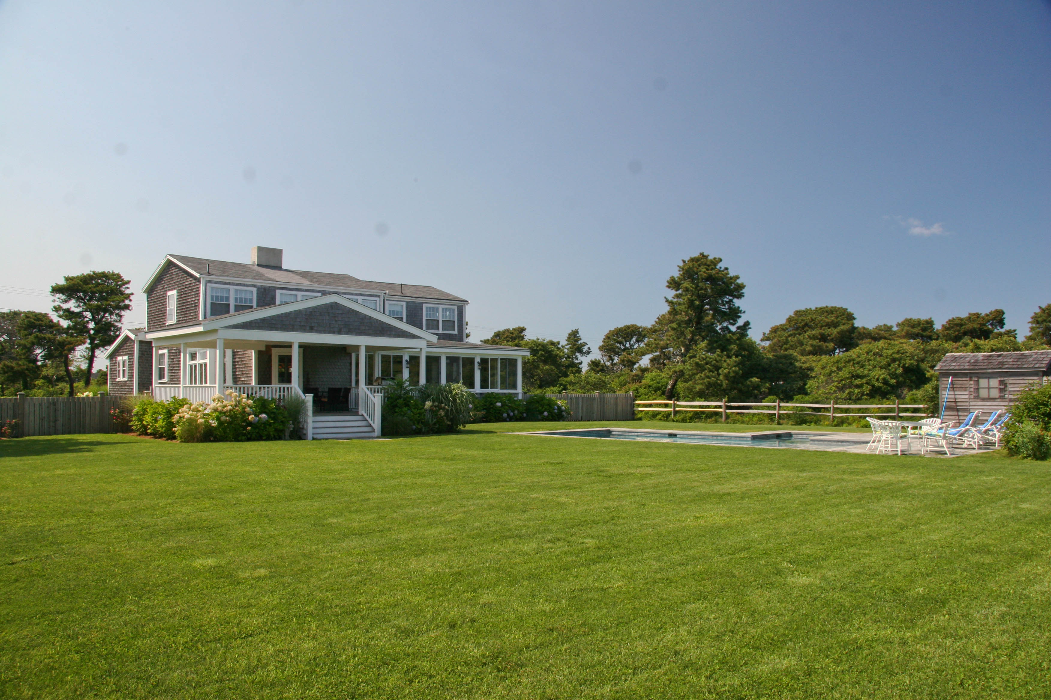 144 Surfside Road Nantucket, MA 02554 - Photo 35 of 46 a front view of a house with a yard table and seating