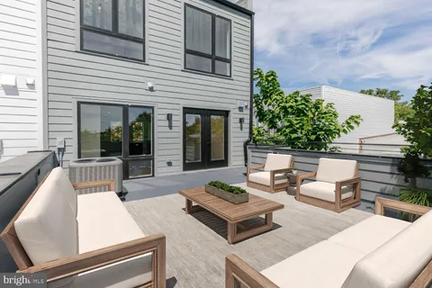 a view of a patio with couches table and chairs and potted plants