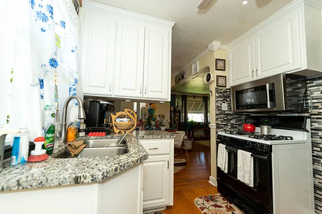 a kitchen with stainless steel appliances granite countertop a stove and cabinets