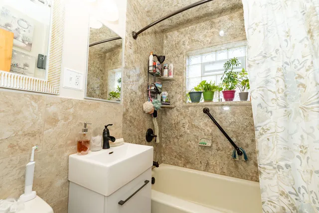 a bathroom with a sink and mirror with bathtub
