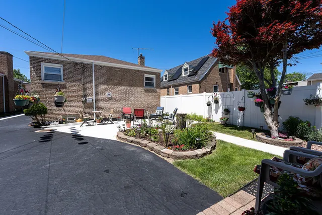 a view of a patio with table and chairs potted plants and a large tree