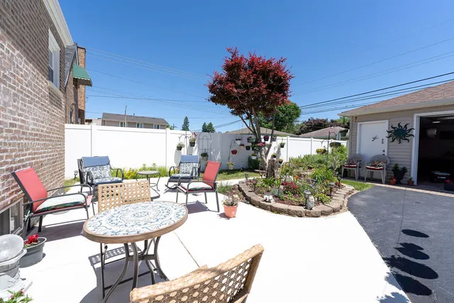 a view of a patio with a table and chairs and potted plants