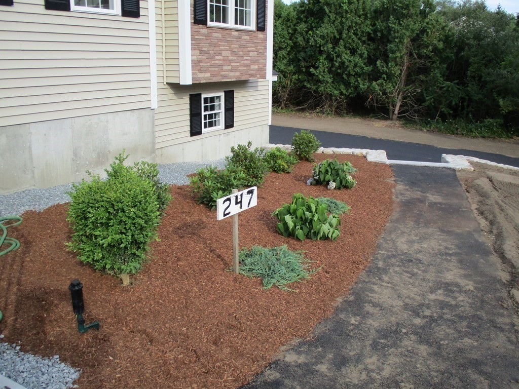 247 High Street Billerica, MA 01862 - Photo 7 of 26 a front view of a house with a yard and a garage