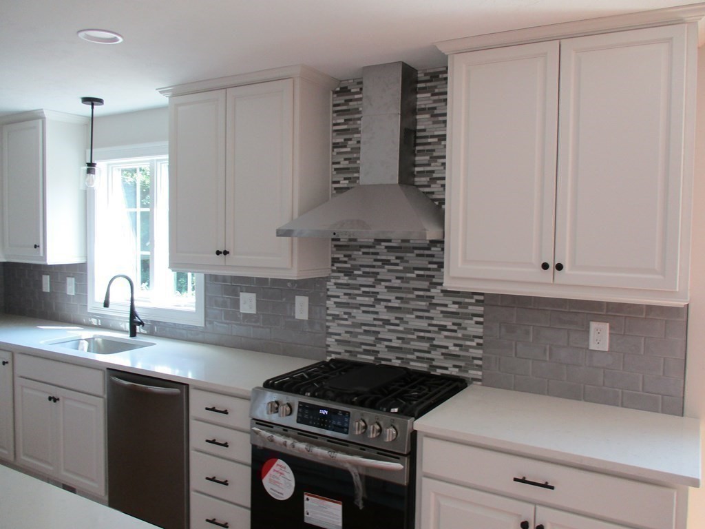 247 High Street Billerica, MA 01862 - Photo 10 of 26 a kitchen with granite countertop a stove sink and cabinets