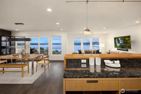 a large living room with stainless steel appliances granite countertop a stove a kitchen island a couch and a view of living room