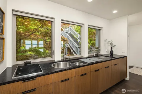 a kitchen with sink a large window and cabinets