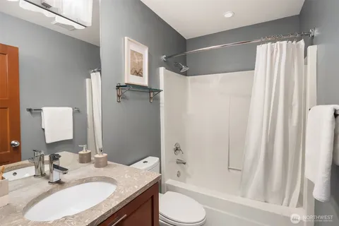 a bathroom with a granite countertop sink toilet and shower