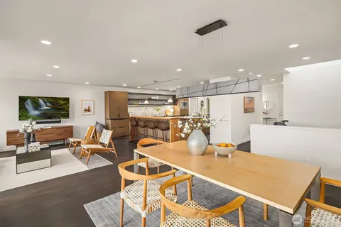 a dinning room and kitchen with a table chairs and chandelier