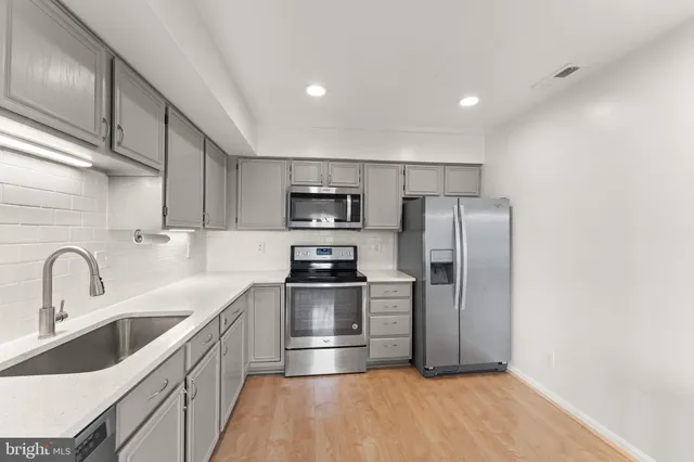 a kitchen with granite countertop a refrigerator and a sink