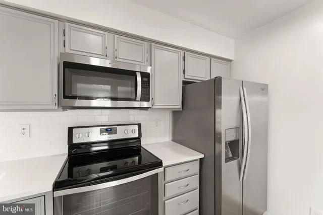 a kitchen with granite countertop cabinets stainless steel appliances and a counter space