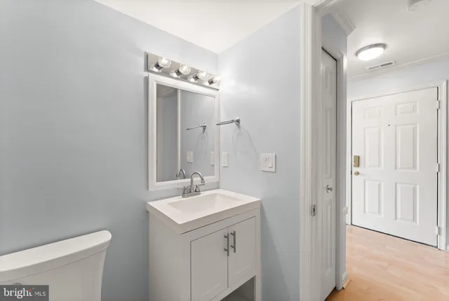 a bathroom with a sink mirror and toilet