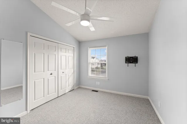 an empty room with fan and windows