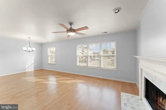 an empty room with windows and fireplace